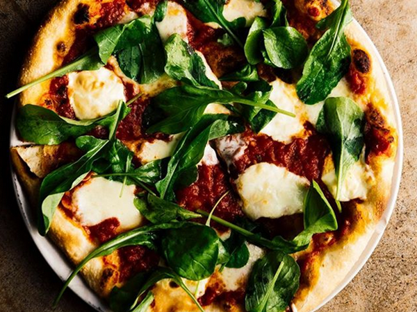 a delicious pizza with fresh arugula